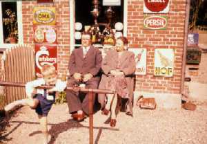 J-bogs hjemmeisde - Mormor og morfar foran butik 1957